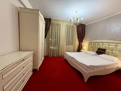 a bedroom with a white bed and a red carpet at Pamporovo Grand Monastery Apartment in Pamporovo