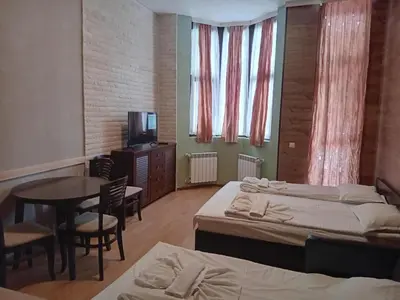 a room with two beds and a table and a television at STUDIO B&K in FLORA BOROVETS in Borovets