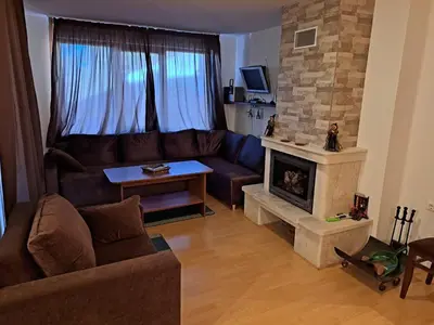 a living room with a couch and a fireplace at Уютен апартамент за зимна почивка в Пампорово in Pamporovo