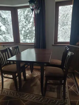 a dining room table and chairs in a room with snow at Уютен апартамент за зимна почивка в Пампорово in Pamporovo