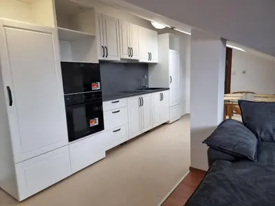 a kitchen with white cabinets and black appliances at Belvedere private apartment 1-bedroom with balcony in Bansko