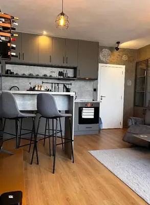 a kitchen and living room with a counter and chairs at CozyHomes in Bansko