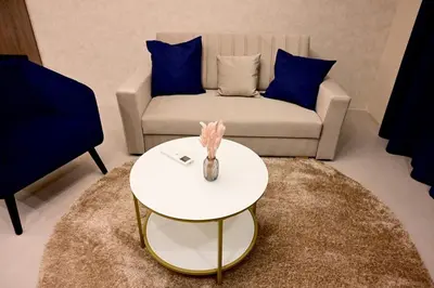a living room with a white table and a couch at Луксозни делукс стаи Мечката in Botevgrad