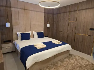 a bedroom with a large bed with blue pillows at Луксозни делукс стаи Мечката in Botevgrad