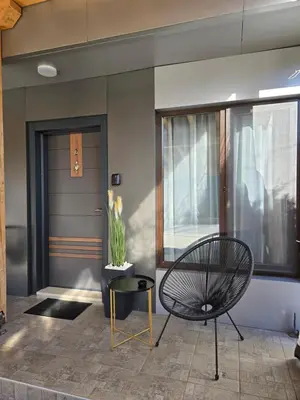 a black chair sitting in front of a door at Луксозни делукс стаи Мечката in Botevgrad