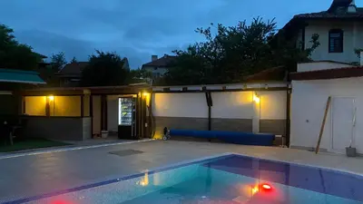 a swimming pool in a backyard at night at Семеен хотел БОНЖУР in Panagyurishte