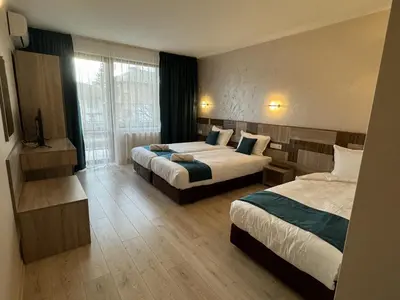 a hotel room with two beds and a window at Семеен хотел БОНЖУР in Panagyurishte