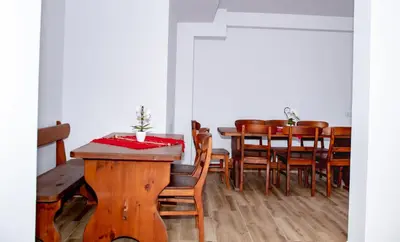 a dining room with a wooden table and chairs at Орбелус in Bansko