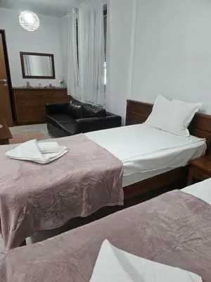 a hotel room with two beds and a chair at Gondola Peak Apartment in Bansko