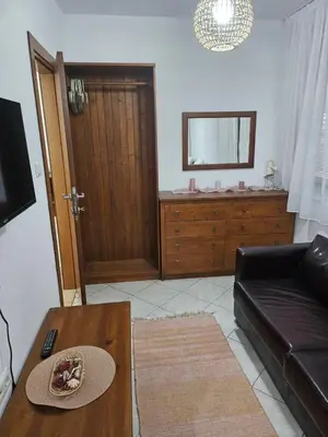a living room with a couch and a mirror at Gondola Peak Apartment in Bansko