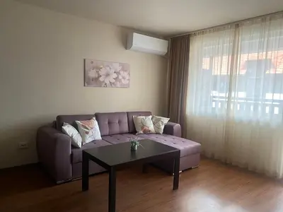 a living room with a purple couch and a table at Royal Towers Bansko Apartment - Gondola in Bansko