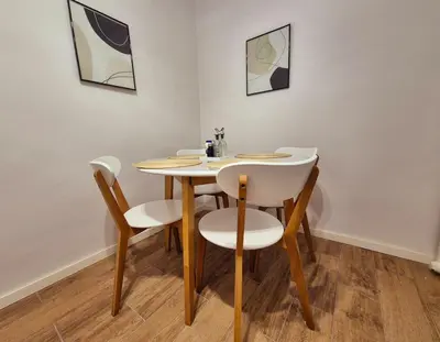 a dining room table with four chairs and a table at Botev's Finest 3BR in Sofia