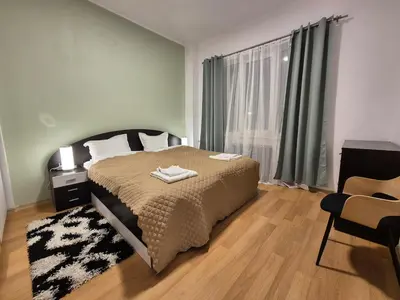 a bedroom with a bed and a large window at Botev's Finest 3BR in Sofia
