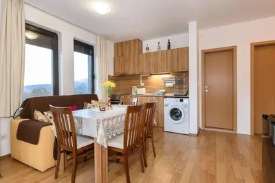 a kitchen and living room with a table and chairs at Niki's cosy place in Bansko