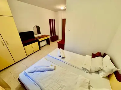 a hotel room with a bed and a television at Basment Rooms - Todorini Kuli in Bansko