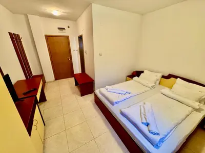 a bedroom with a bed with towels on it at Basment Rooms - Todorini Kuli in Bansko