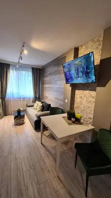 a living room with a couch and a table at Luxuriously furnished and cozy studio - Magnolia in Borovets