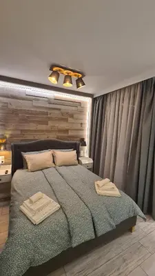 a bedroom with a large bed with two towels on it at Luxuriously furnished and cozy studio - Magnolia in Borovets