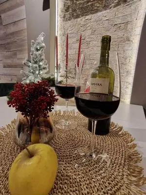 a table with two glasses of wine and an apple at Luxuriously furnished and cozy studio - Magnolia in Borovets