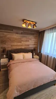 a bedroom with a large bed with a wooden wall at Luxuriously furnished and cozy studio - Magnolia in Borovets