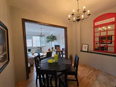 a dining room and living room with a table and chairs at Cozy Suite Vitosha street Center in Sofia