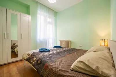 a bedroom with a bed with two blue towels on it at 2 bedroom Urban retreat in Sofia