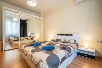 a bedroom with a large bed and a large mirror at 2 bedroom Urban retreat in Sofia