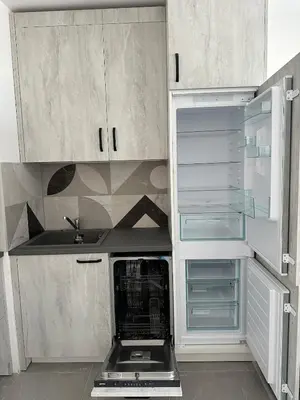 a kitchen with white cabinets and an empty refrigerator at Lovely Stylish Brand New Flat in Sofia