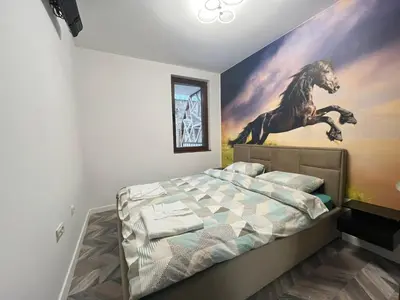a bedroom with a painting of a horse on the wall at Ski cosy apartment 5 in Bansko