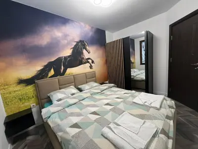 a bedroom with a painting of a horse on the wall at Ski cosy apartment 5 in Bansko