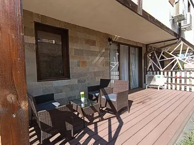 a patio with chairs and a table on a deck at Ski cosy apartment 5 in Bansko