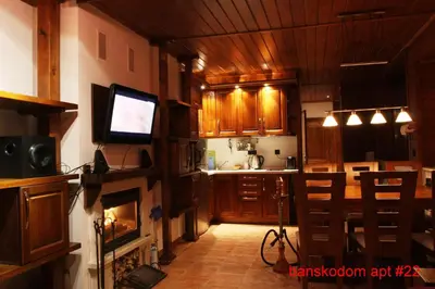 a kitchen with a fireplace and a television in a room at Banskodom in Bansko