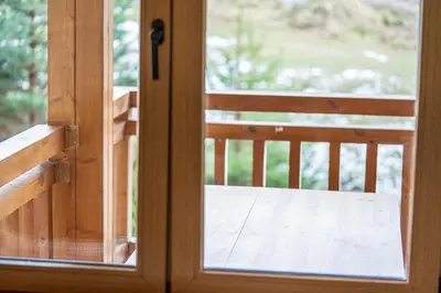 a sliding glass door with a view of a porch at Host2U Mountain 2 Bedrooms - Fireplace in Bansko