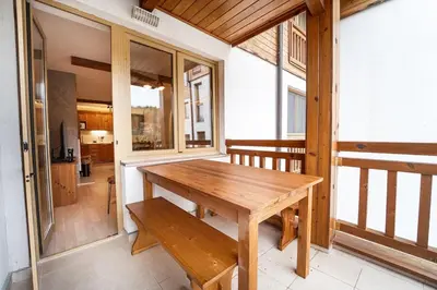 a wooden table on the balcony of a house at Host2U Mountain 2 Bedrooms - Fireplace in Bansko