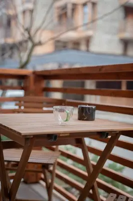 a wooden picnic table with a glass bowl on it at Host2U Authentic Bansko Apartment - Free Parking in Bansko