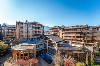 an aerial view of a building with tall buildings at Host2U Authentic Bansko Apartment - Free Parking in Bansko