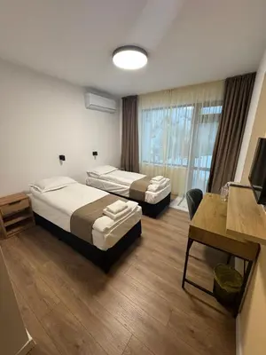 a hotel room with two beds and a desk at Къща за гости ЕСТЕТ ESTET Guest house in Oreshak