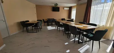 a restaurant with wooden tables and chairs in a room at Къща за гости ЕСТЕТ ESTET Guest house in Oreshak