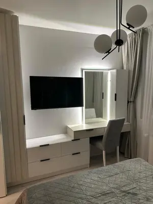 a bedroom with a desk with a television on a wall at Cherry in Sofia