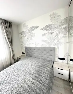 a bedroom with a bed and a wall with plants at Cherry in Sofia