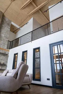 a living room with two chairs and windows at Chalet Pamporovo in Pamporovo