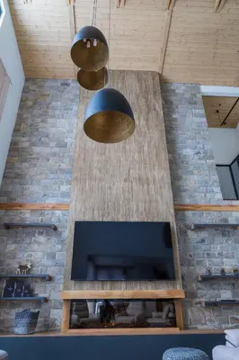 a room with a stone wall and two lights at Chalet Pamporovo in Pamporovo