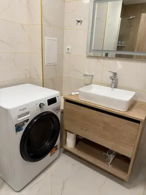 a washing machine in a bathroom next to a sink at PanOrama Luxury Apartments in Panagyurishte