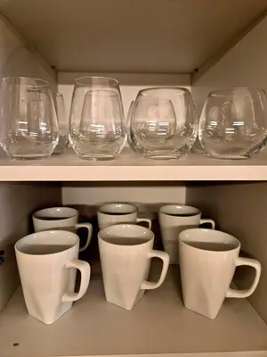 a row of glasses and cups on a shelf at The VERTEX in Sofia