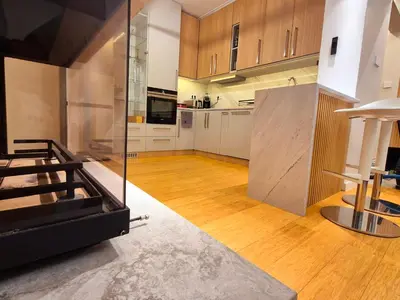 a large kitchen with wooden floors and white cabinets at The VERTEX in Sofia