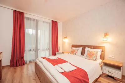 a bedroom with a large bed with red curtains at Golden Lake 526 at Oak Residence in Smolyan