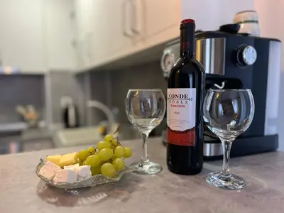 a bottle of wine and two wine glasses on a counter at Snowflake- Luxury stay with a Bottle of Wine,free Parking and SPA in Royal Park in Bansko