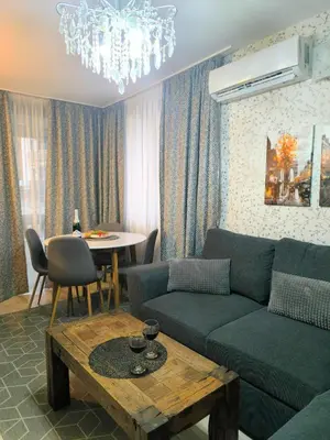 a living room with a couch and a table at Snowflake- Luxury stay with a Bottle of Wine,free Parking and SPA in Royal Park in Bansko