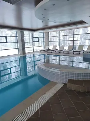 a large swimming pool with chairs in a building at Forest Chamkoria Apartment in Borovets