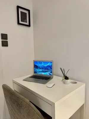 a laptop computer sitting on top of a white desk at Pirin Cozy Escape 8 min walk from ski lift - Private Apartment Grand Bansko 1 in Bansko